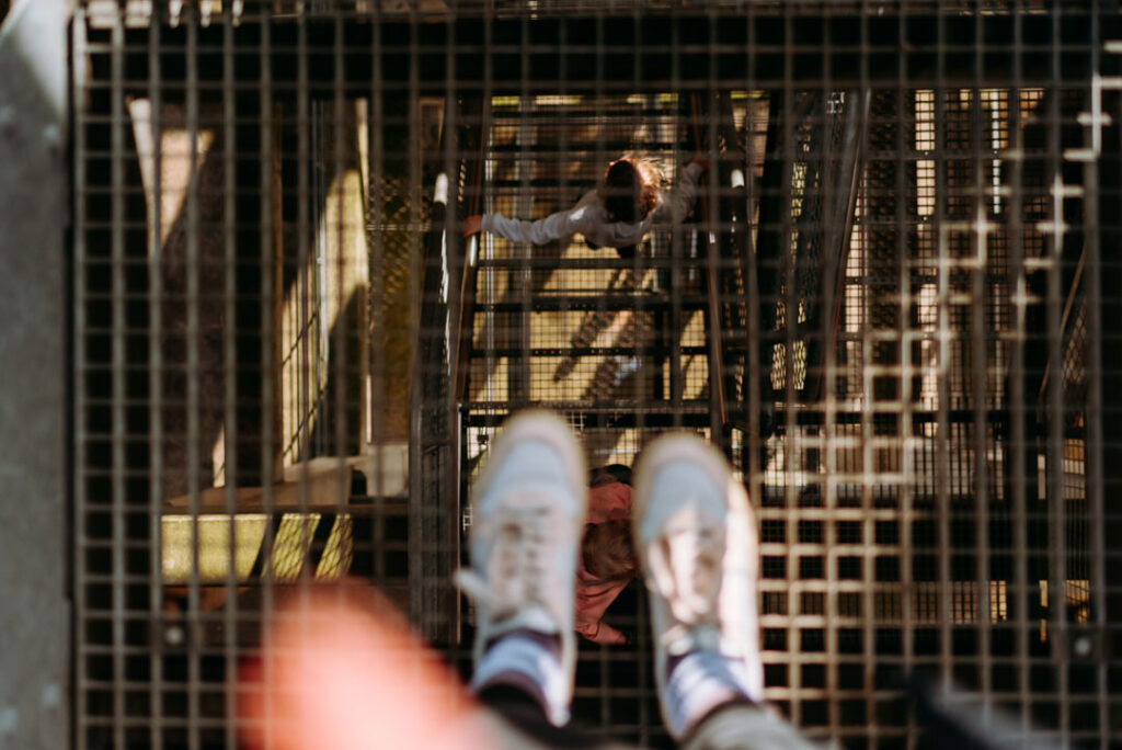 Blick nach unten durch das Gitter auf die Treppen und meine Familie unter mir