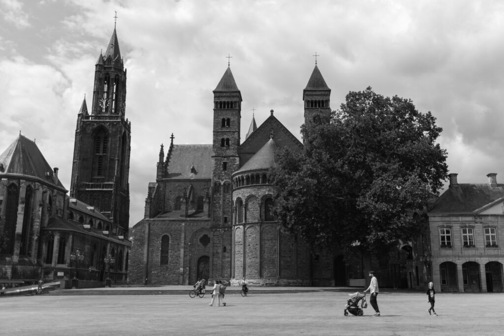 Großer Platz mit Kirche und Menschen auf dem Vrijthof in Maastricht in Schwarz-Weiß.
