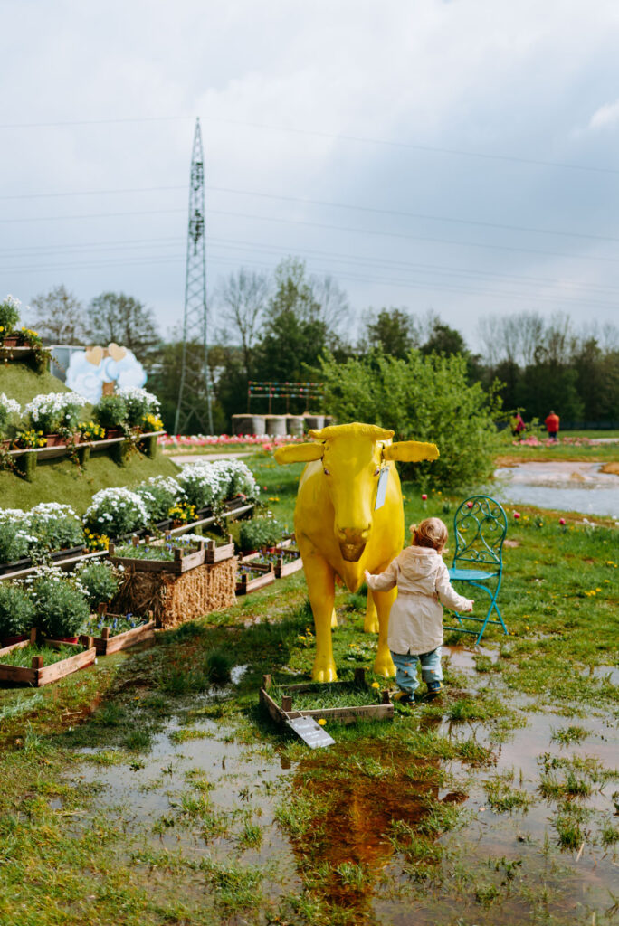 Kind vor einer gelben Kuhfigur auf dem Gelände des Krewelshofs