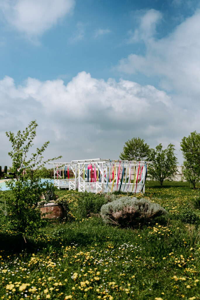 Weiße Pergola in einer blühenden Frühlingswiese auf dem Krewelshof