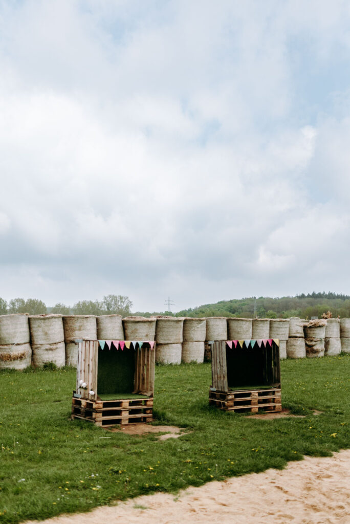Kleine Sitzkästen vor einer Wand aus Strohballen auf dem Krewelshof