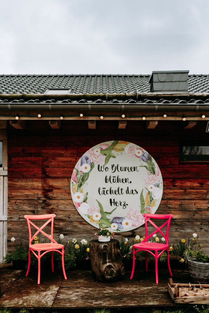 Blumenschild mit dem Spruch „Wo Blumen blühen lächelt das Herz“ auf dem Krewelshof